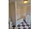 Bathroom featuring a shower-tub combo and a white vanity with checkerboard tile floors at 3354 Altamahaw Church Rd, Elon, NC 27244