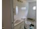 Standard bathroom with vanity sink, toilet, and green-trimmed tub beneath a small window at 3354 Altamahaw Church Rd, Elon, NC 27244