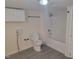 Cozy bathroom features white fixtures, including a tub-shower combo and cabinets, complemented by gray vinyl flooring at 3354 Altamahaw Church Rd, Elon, NC 27244