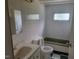Standard bathroom with vanity sink, toilet, and green-trimmed tub beneath a small window at 3354 Altamahaw Church Rd, Elon, NC 27244