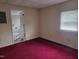 Bedroom showing a standard window, red carpet and an entry door leading to the bathroom at 3354 Altamahaw Church Rd, Elon, NC 27244