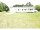 The exterior of this single story home has black shutters, a charming front porch and a large lawn at 3354 Altamahaw Church Rd, Elon, NC 27244