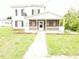 Two-story home with black shutters and a brick and white porch at 3354 Altamahaw Church Rd, Elon, NC 27244