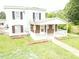 A cozy front porch with brick accents, white railing, and a well-manicured lawn at 3354 Altamahaw Church Rd, Elon, NC 27244