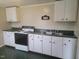 A kitchen featuring white cabinets, green countertops, and basic appliances at 3354 Altamahaw Church Rd, Elon, NC 27244