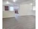 Open-concept living room with modern gray flooring, white walls, and view into the kitchen at 3354 Altamahaw Church Rd, Elon, NC 27244