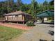 Charming single-story home with a spacious deck, lush greenery, and a convenient carport on a sunny day at 3405 Ode Turner Rd, Hillsborough, NC 27278