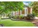 View of backyard featuring well manicured landscaping, bay windows, and brick exterior at 3509 Carlton Square Pl, Raleigh, NC 27612
