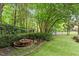 Backyard landscape with mature trees, a water feature and a small storage shed at 3509 Carlton Square Pl, Raleigh, NC 27612