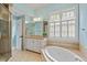 Bathroom with dual vanities, soaking tub, framed mirrors, and natural light from the windows at 3509 Carlton Square Pl, Raleigh, NC 27612