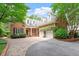 Charming brick home with dormers, lush landscaping, and a brick driveway leading to a three-car garage at 3509 Carlton Square Pl, Raleigh, NC 27612