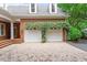 Two car garage with climbing vines, brick facade and brick paver driveway at 3509 Carlton Square Pl, Raleigh, NC 27612