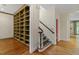 Hallway with hardwood floors, staircase, and built-in bookcase providing ample storage at 3509 Carlton Square Pl, Raleigh, NC 27612