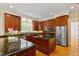 Gourmet kitchen featuring granite countertops, stainless steel appliances, and custom cabinetry at 3509 Carlton Square Pl, Raleigh, NC 27612