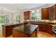 Open kitchen offers dark wood cabinets, granite counters, large island, and ample natural light at 3509 Carlton Square Pl, Raleigh, NC 27612