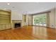 Bright living room featuring a fireplace, built-in shelving, hardwood floors, and access to outdoor light at 3509 Carlton Square Pl, Raleigh, NC 27612