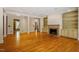 Large living room with hardwood floors, built-in shelving, a fireplace, and bright natural light at 3509 Carlton Square Pl, Raleigh, NC 27612