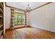 Bright office with hardwood floors, built-in bookshelves, and a large window offering green views at 3509 Carlton Square Pl, Raleigh, NC 27612