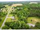 Beautiful aerial shot showcasing a home with a well-maintained lawn, surrounded by lush greenery and open fields at 3906 Union Ridge Rd, Burlington, NC 27217