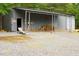 Exterior shot of a metal outbuilding with covered storage and ample space for projects or storage at 3906 Union Ridge Rd, Burlington, NC 27217