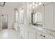 Elegant bathroom features dual sinks, granite countertops, decorative mirrors, and chandelier lighting at 3908 Chaumont Dr, Apex, NC 27539