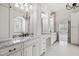 Bright bathroom featuring double vanities, granite counters, decorative mirrors, and modern fixtures at 3908 Chaumont Dr, Apex, NC 27539