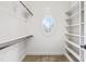 Well-organized closet with custom shelves, hanging racks, unique round window, and neutral carpet at 3908 Chaumont Dr, Apex, NC 27539