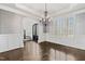 Elegant dining room boasting hardwood floors, wainscoting, and a statement chandelier at 3908 Chaumont Dr, Apex, NC 27539
