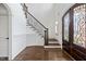 Grand foyer with hardwood floors, staircase with iron railings, and decorative front door at 3908 Chaumont Dr, Apex, NC 27539