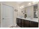 Bathroom featuring a double vanity with brown cabinets, a large mirror, and modern lighting at 4612 Hanging Fern Ln, Raleigh, NC 27604