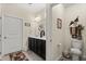 Bathroom featuring double sink vanity, toilet, white door, and decorated with a welcome sign at 4612 Hanging Fern Ln, Raleigh, NC 27604