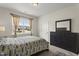 Bedroom featuring a window with natural light, a dark wood dresser, and a patterned comforter at 4612 Hanging Fern Ln, Raleigh, NC 27604