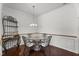 A dining room featuring a glass top table with seating for four, lit by a pendant light at 4612 Hanging Fern Ln, Raleigh, NC 27604