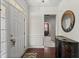 Bright foyer with hardwood floors, decorative mirror, console table, and view into other rooms at 4612 Hanging Fern Ln, Raleigh, NC 27604