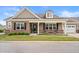 Beautiful home with a covered porch, dark shutters, landscaped lawn, and attached garage at 4612 Hanging Fern Ln, Raleigh, NC 27604