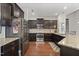 A kitchen with dark cabinets, stainless steel appliances, and granite countertops at 4612 Hanging Fern Ln, Raleigh, NC 27604