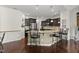 Open kitchen featuring a granite island with seating, dark wood cabinets, and stainless steel appliances at 4612 Hanging Fern Ln, Raleigh, NC 27604