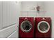 Laundry room featuring a pair of red LG washer and dryer sets next to a door at 4612 Hanging Fern Ln, Raleigh, NC 27604
