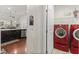 Laundry room featuring a pair of red LG washer and dryer sets connected to a doorway to the kitchen at 4612 Hanging Fern Ln, Raleigh, NC 27604