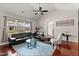 Bright living room with a fireplace, dark leather furniture, hardwood floors, and large windows at 4612 Hanging Fern Ln, Raleigh, NC 27604