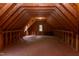Unfinished attic space displaying exposed wood beams, open rafters, and window at 504 Belmont Cir, Wake Forest, NC 27587