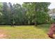 Expansive backyard with lush lawn, mature trees, and a wooded perimeter providing privacy and a serene atmosphere at 504 Belmont Cir, Wake Forest, NC 27587