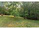 Large backyard featuring a lawn, mature trees, and a wooded border, perfect for outdoor activities and privacy at 504 Belmont Cir, Wake Forest, NC 27587