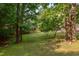 Lush backyard with a lawn, mature trees, and a private setting, perfect for outdoor activities and relaxation at 504 Belmont Cir, Wake Forest, NC 27587