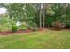 Lush backyard featuring green grass and mature trees, creating a peaceful outdoor space at 504 Belmont Cir, Wake Forest, NC 27587
