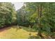 Expansive backyard features green grass and mature trees, creating a private retreat at 504 Belmont Cir, Wake Forest, NC 27587