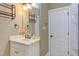 A bathroom with a white vanity and framed mirror with decorative sconces and a view of the tub/shower combo at 504 Belmont Cir, Wake Forest, NC 27587