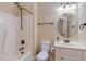 A clean and well-lit bathroom featuring a tub, toilet, vanity and round mirror at 504 Belmont Cir, Wake Forest, NC 27587