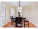 Charming dining area featuring wood floors, seating for six, white shutters, and an elegant chandelier at 504 Belmont Cir, Wake Forest, NC 27587