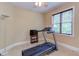 Neutral exercise room featuring a treadmill, television, ceiling fan, and window at 504 Belmont Cir, Wake Forest, NC 27587